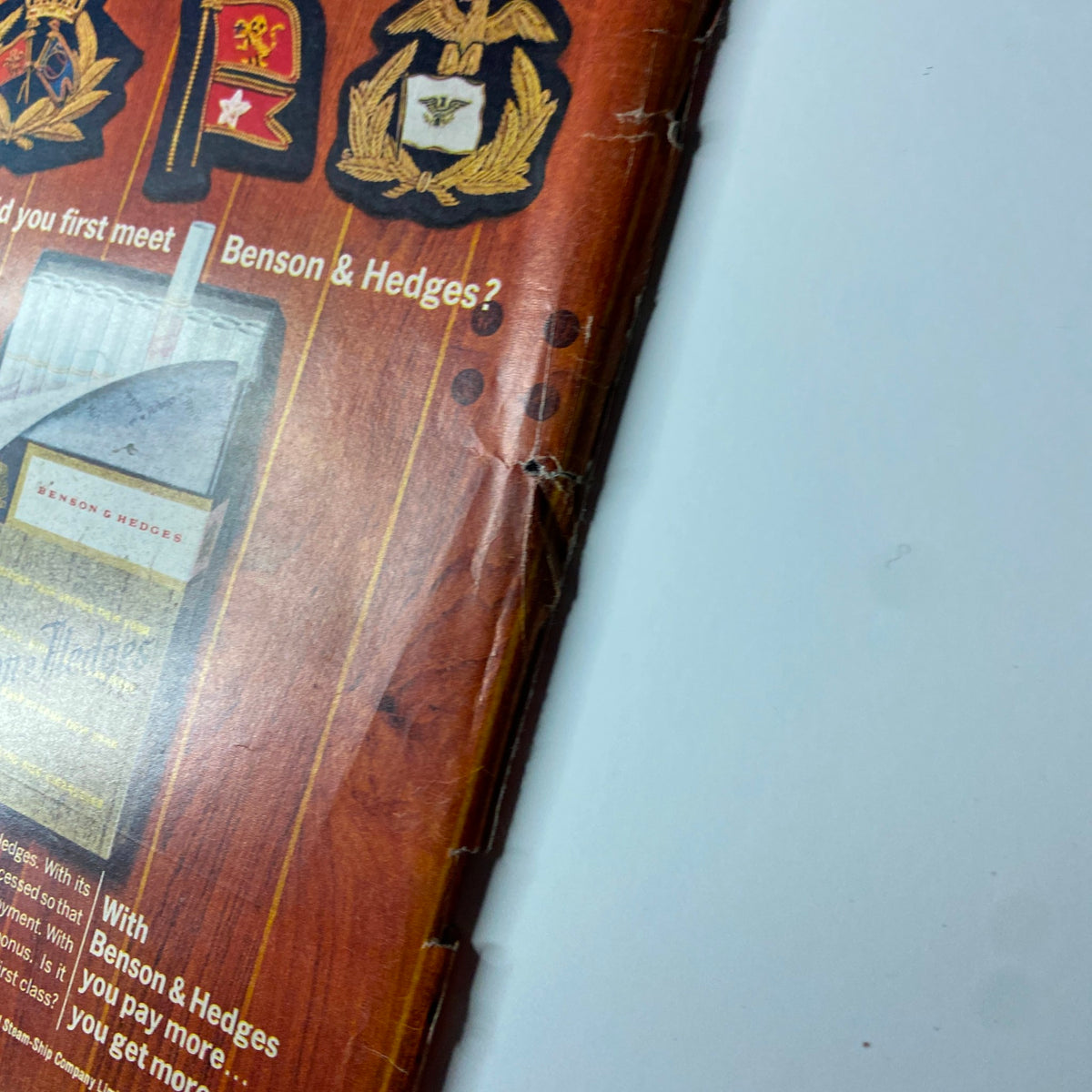 Close-up view of the Benson & Hedges cigarette advertisement from Time Magazine March 15, 1963 Vol 81 No. 11, showcasing military emblems and the cigarette pack design, emphasizing the premium experience.