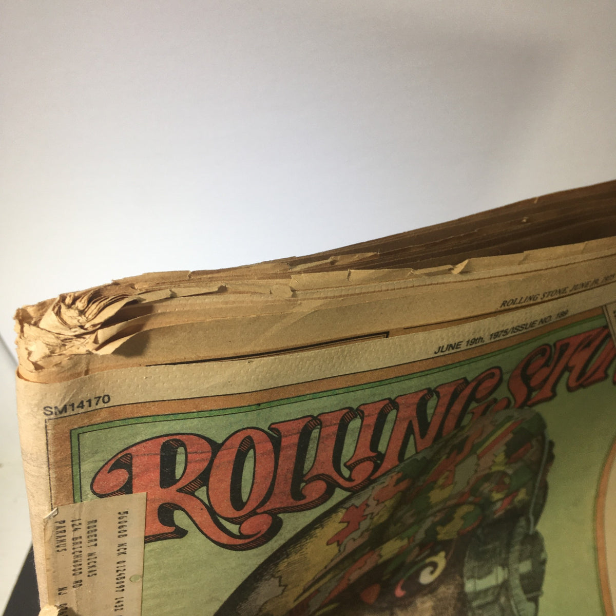 Top view of the vintage Rolling Stone Magazine, dated June 19, 1975, illustrating the edges with wear and tear, typical of a collectible item.