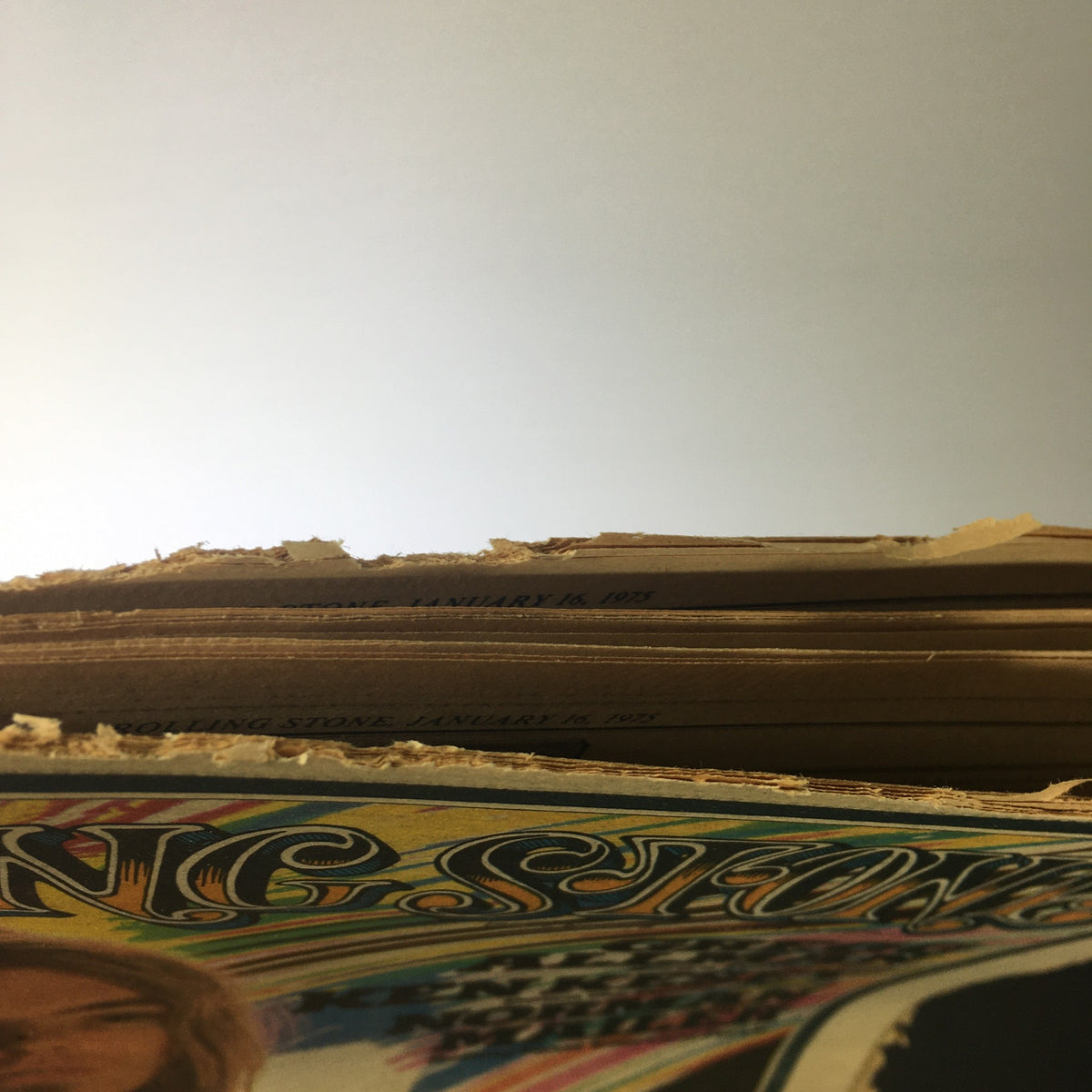 Top view of the spine of Vintage Rolling Stone Magazine January 16 1975, showing the date and issue number, revealing age-related wear typical of vintage magazines.