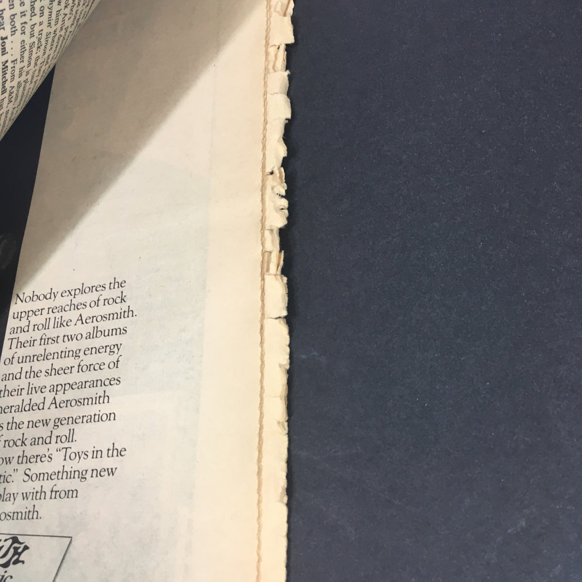 Inside view of a page from the vintage Rolling Stone Magazine, May 22, 1975, focusing on text and edge damage, reflecting its age and collectible status.
