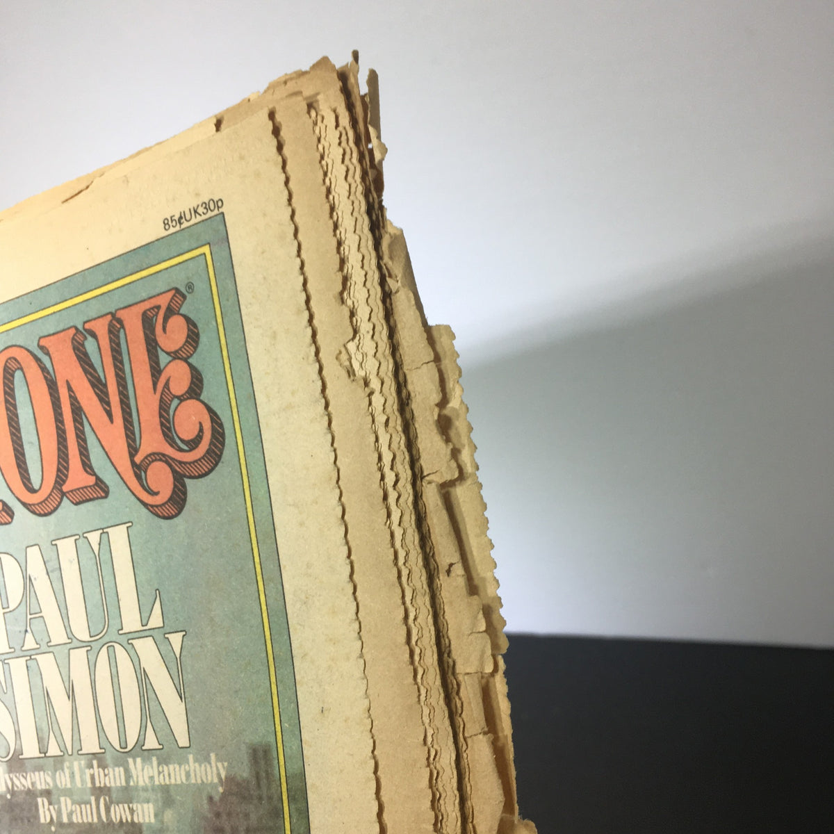 Close-up of the spine of the VTG Rolling Stone Magazine July 1, 1975 featuring Paul Simon, showing wear and tear as a vintage collectible.