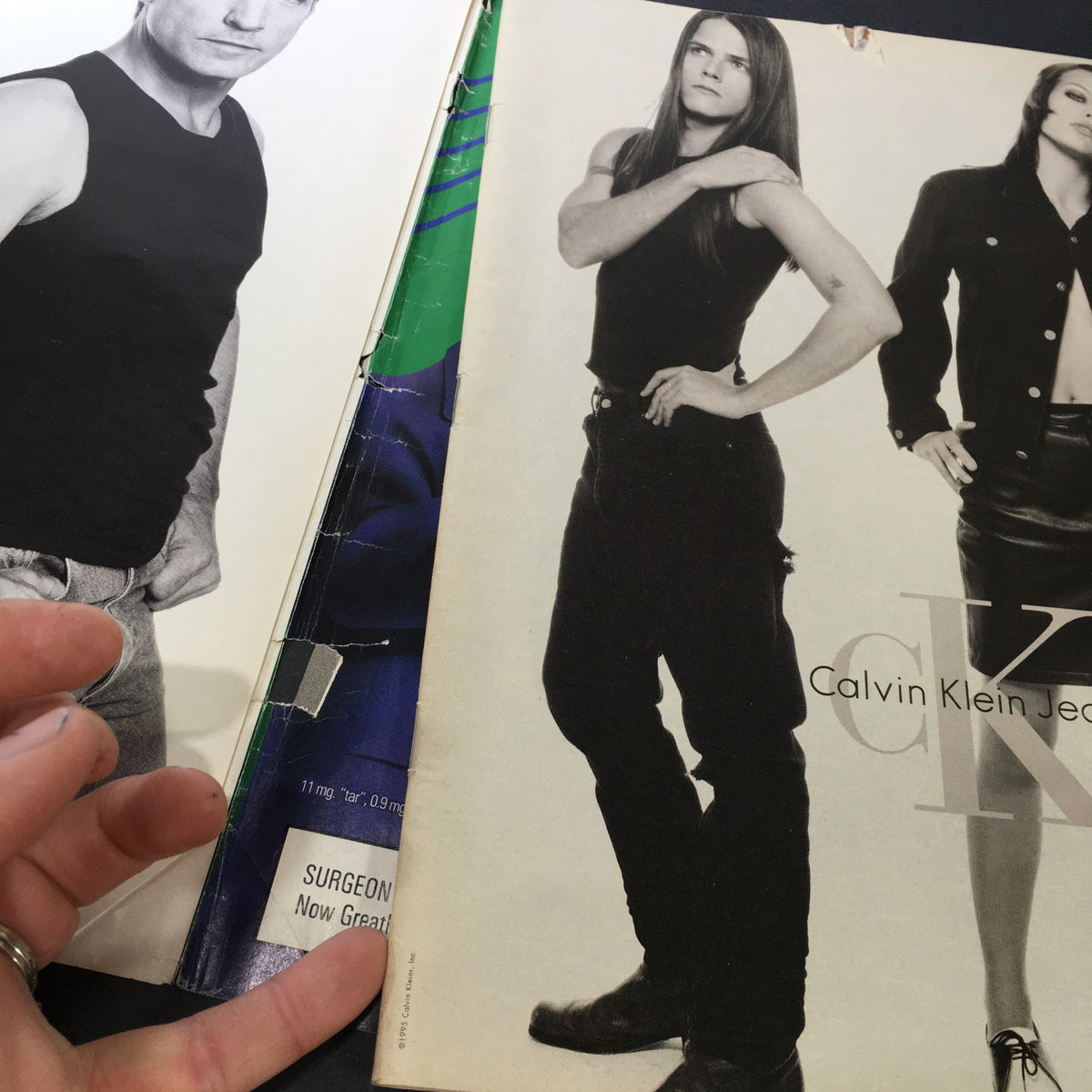 Inside page of VTG Rolling Stone Magazine December 14 1995 displaying advertisements, including a Calvin Klein Jeans ad, highlighting the fashion of the 1990s.