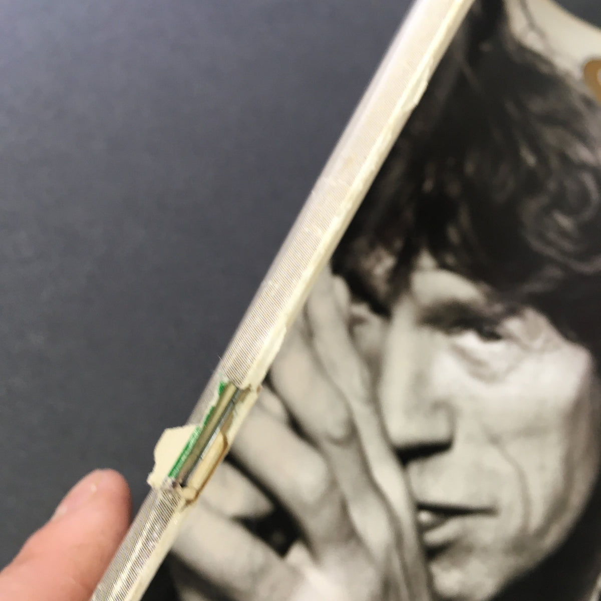 Detailed view of the spine of the vintage Rolling Stone Magazine from December 14, 1995, capturing the magazine's condition with visible wear, emphasizing its significance in rock history featuring Mick Jagger.