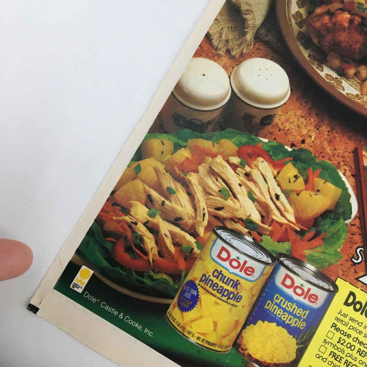 Close-up of the 1984 Dole Chunk Pineapple and Chicken Circular Coupon Advertisement showing a plate of pineapple salad and cans of Dole chunk and crushed pineapple.