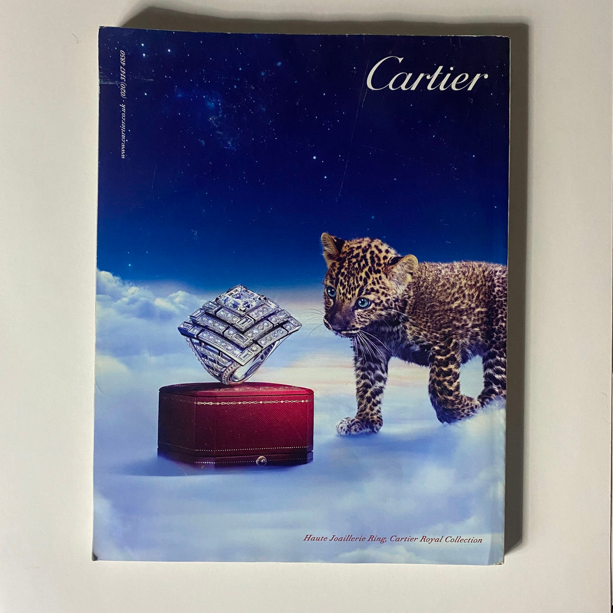 Cover of a Cartier brochure featuring a luxury ring with a leopard, highlighting high-end jewelry and elegant design.