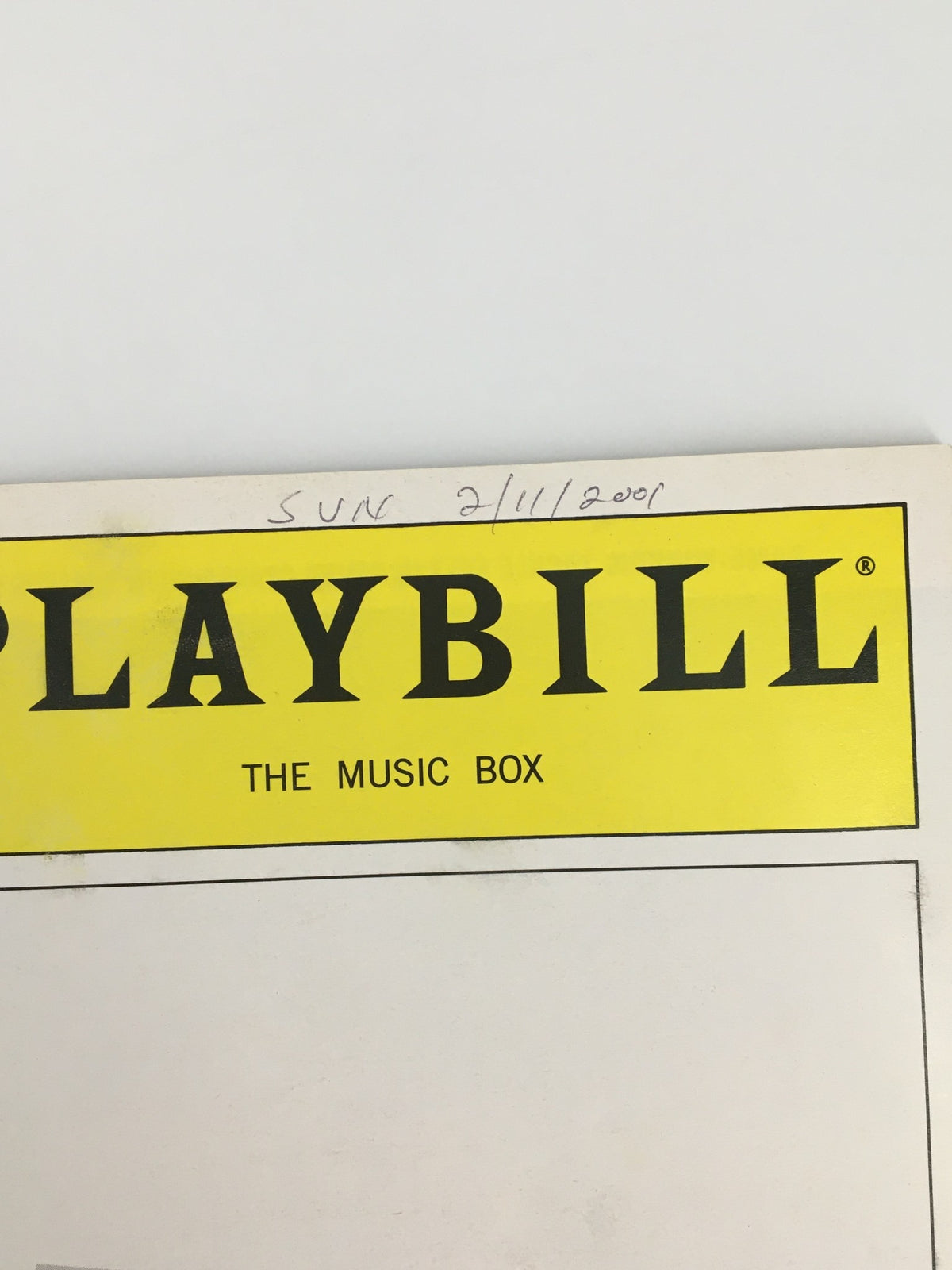 Close-up view of the top section of the 2001 Playbill The Music Box featuring Neil Simon's The Dinner Party with handwritten date.