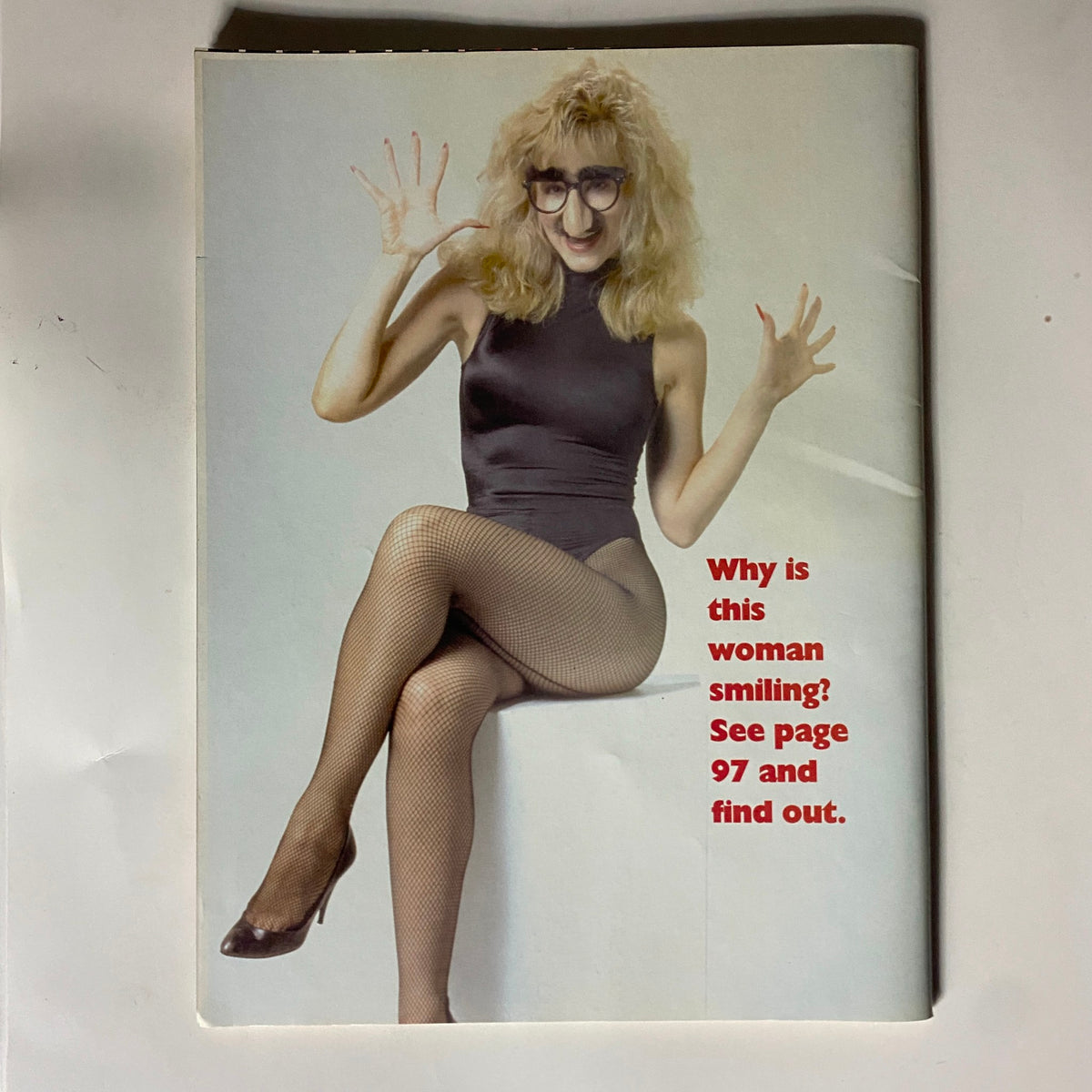 Cover photo from The Comedy Magazine December 1993, featuring a woman in a stylish costume with fishnet stockings, posing playfully. Text reads: 'Why is this woman smiling? See page 97 and find out.' This vintage magazine showcases comedy personalities.