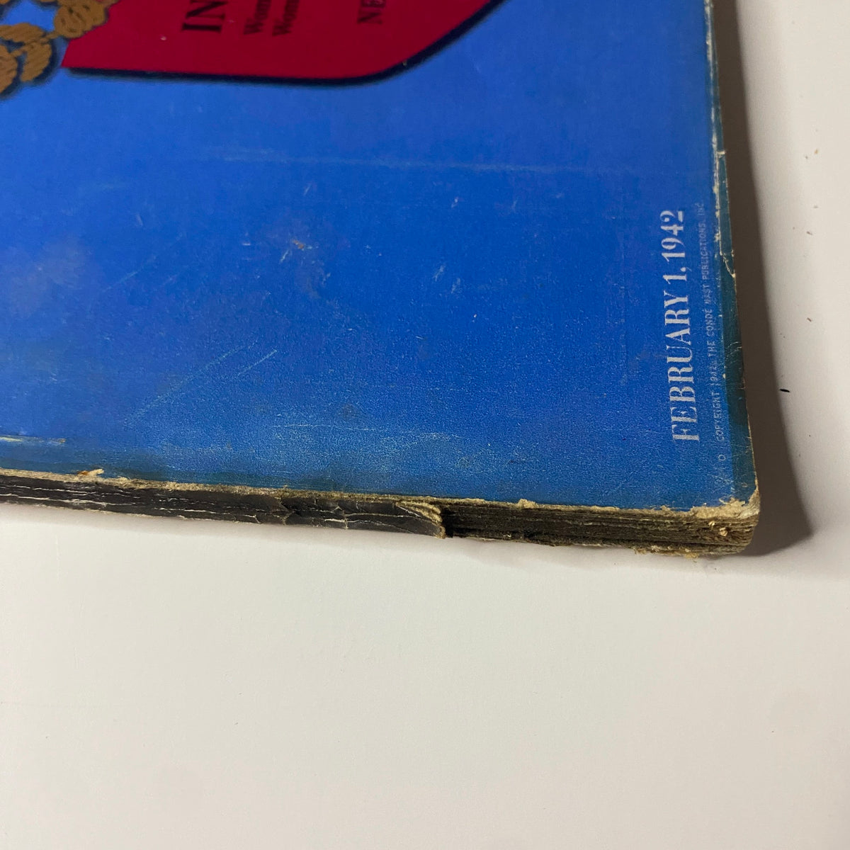 Vogue Magazine February 1, 1942 Life in Wartime Women in the Morale Corps - close-up of the magazine's spine showing historical wear and damage typical of vintage publications.