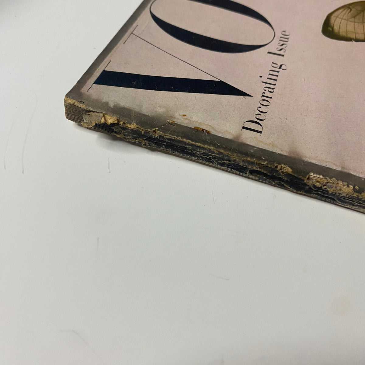 Side view of the Vogue Magazine April 15, 1947 Decorating Issue, showcasing the worn edges and vintage characteristics of the magazine.