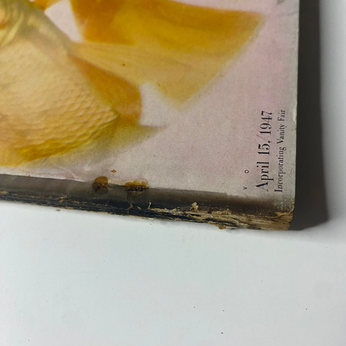 Close-up of the bottom spine of Vogue Magazine April 15, 1947 Decorating Issue, highlighting its vintage condition and details.