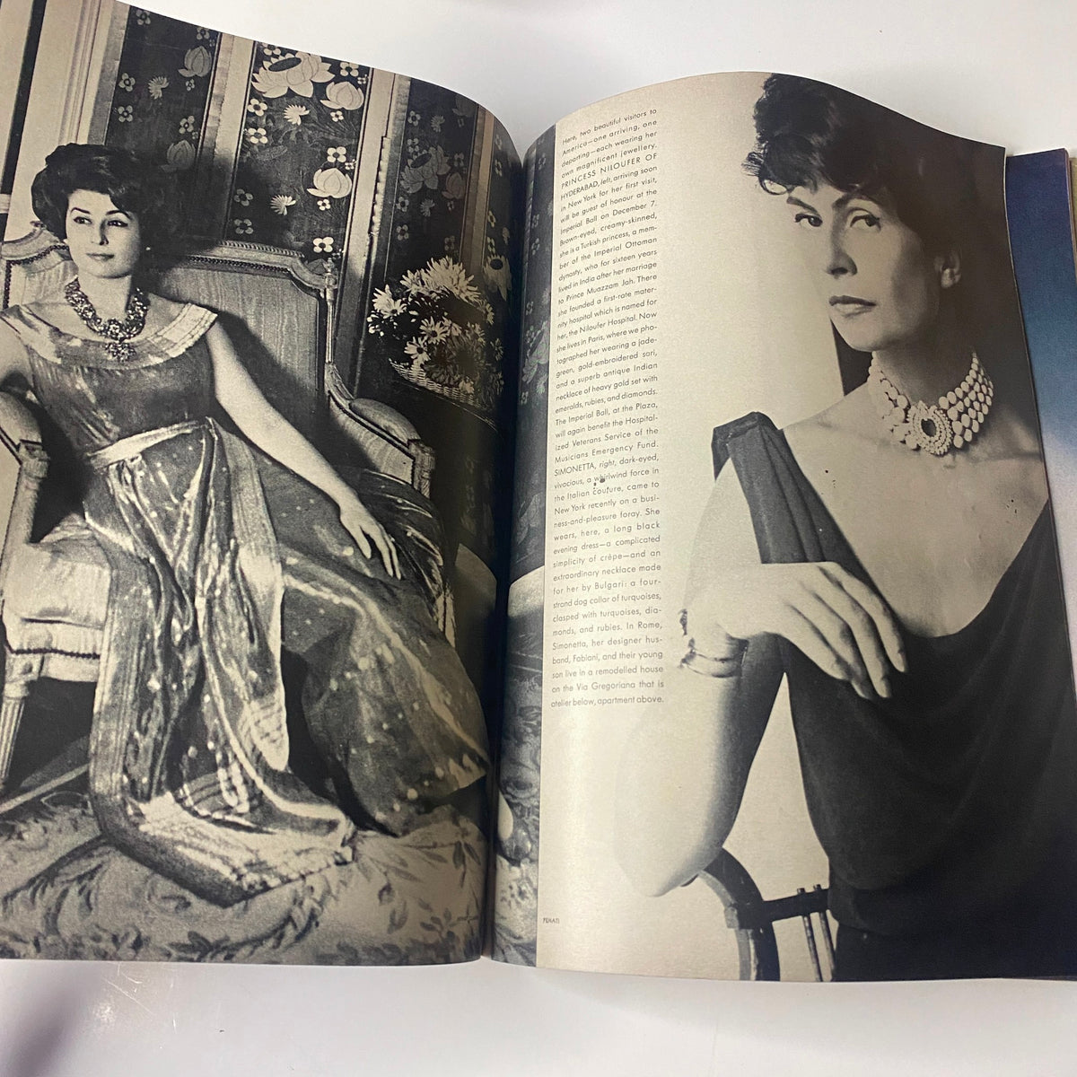 Elegant fashion photography from Vogue Magazine November 1, 1961, displaying two models showcasing chic evening wear adorned with exquisite jewelry in a luxurious setting.