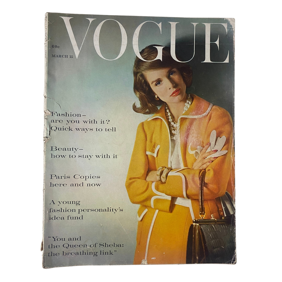 Vogue Magazine March 15, 1960 featuring cover model Lisa Bigelow, photographed by Horst P. Horst. The issue showcases a stylish orange coat with white accessories, emphasizing mid-century fashion elegance.