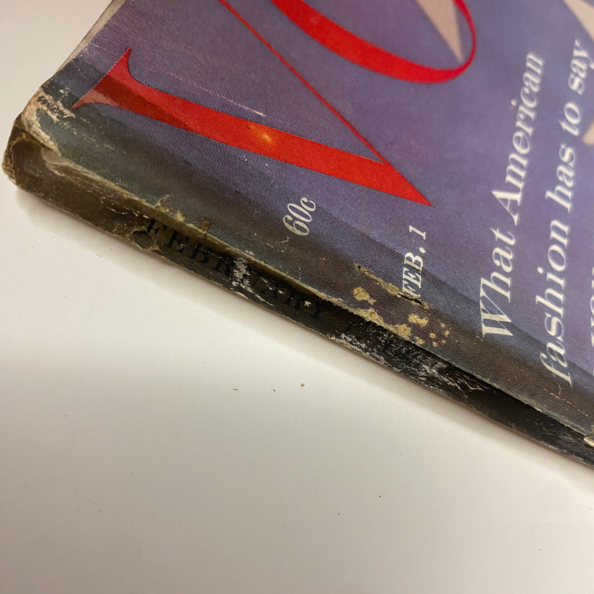 Spine detail of Vogue Magazine February 1, 1961 showing signs of wear, preserving the integrity of this collectible item featuring Dorothy McGowan on the cover.