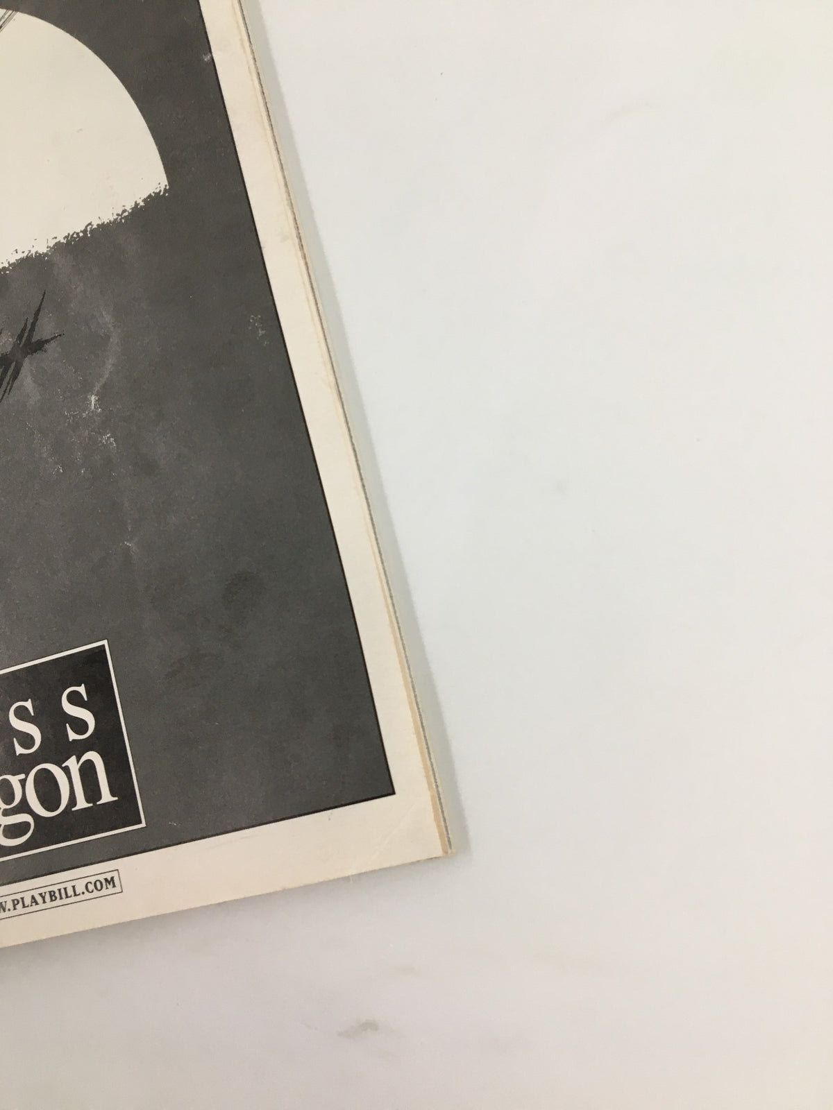 Side view of the 2000 Miss Saigon Playbill, featuring a minimalist design with the musical's title and artistic elements.