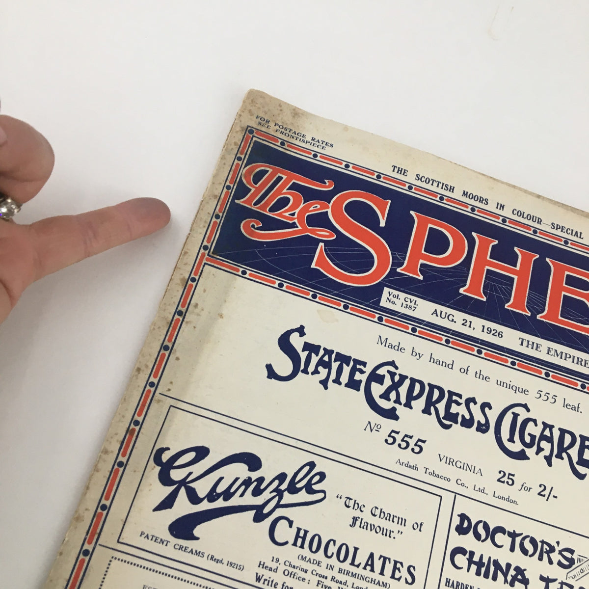 Close-up of The Sphere Newspaper cover from August 21, 1926, showing the edge detailing and advertisements for State Express Cigarettes and other brands.