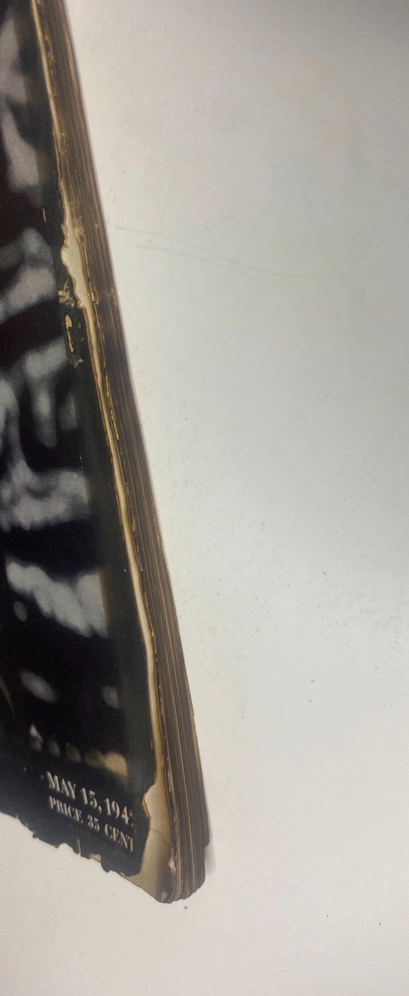 Close-up of the aging edge of Vogue Magazine May 15, 1942, revealing delicate condition and historic value, with a visible price of 35 cents.