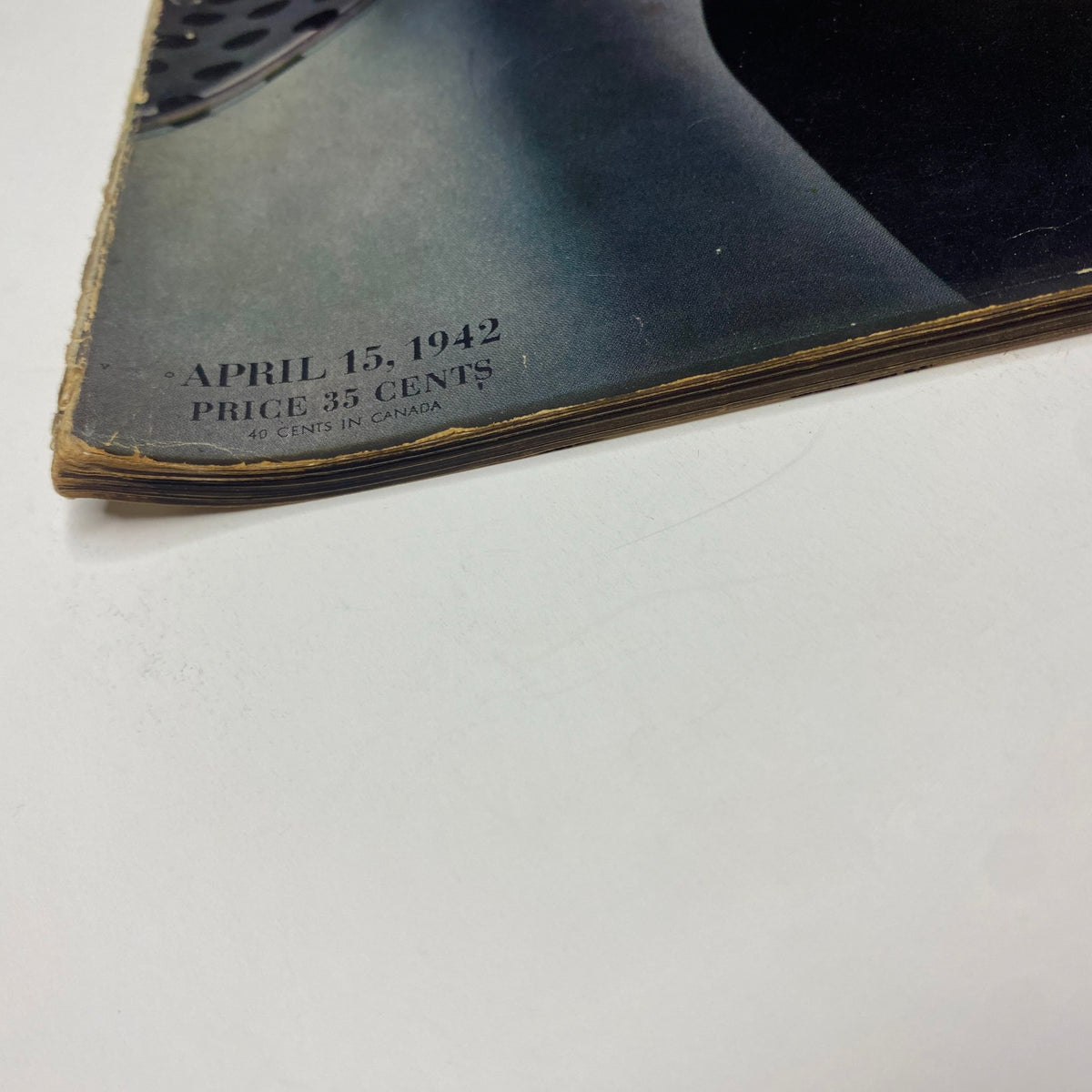 Close-up of the April 15, 1942 Vogue Magazine cover featuring 'Our Ration-al Lives' by John Rawlings, showcasing vintage wear and character, with the date and price visible.