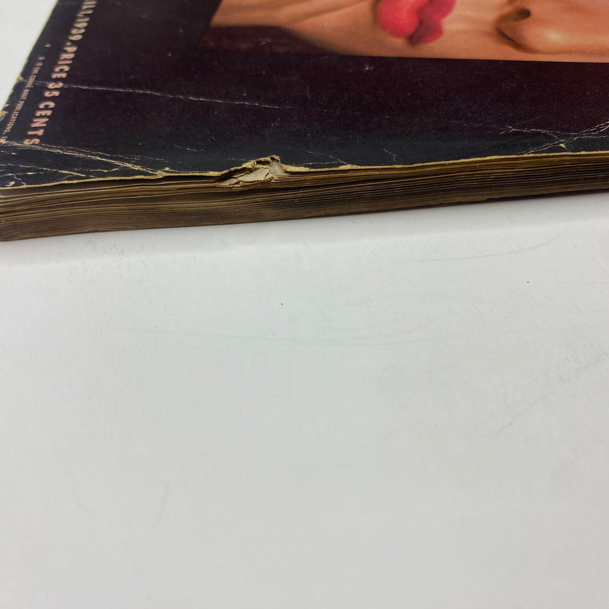Detailed image of the distressed spine of Vogue Magazine April 1, 1939, highlighting the magazine's age and character.