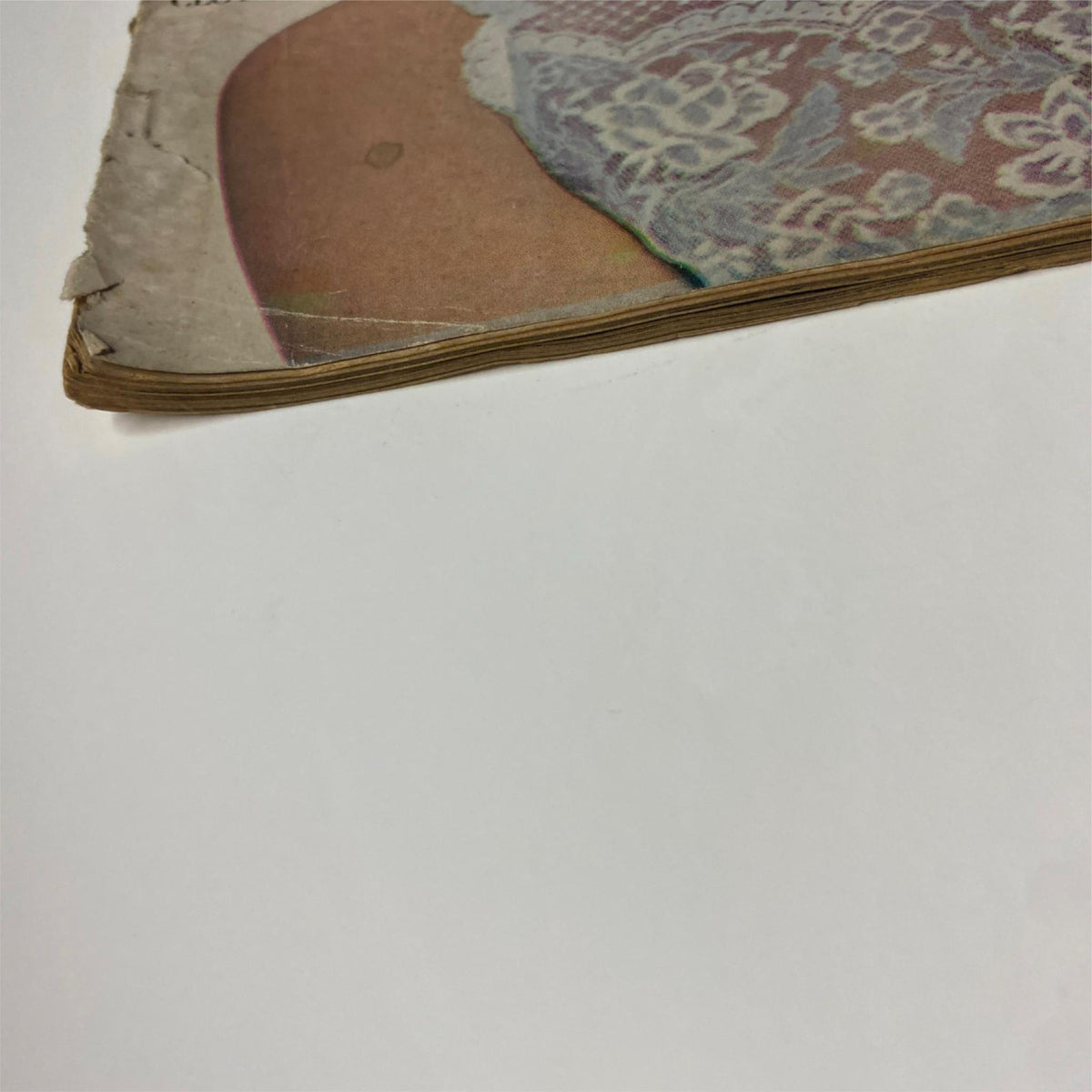 Close-up view of the edge of a page from Vogue Magazine January 15, 1964, showing vintage characteristics and minor tears, symbolizing the magazine's historical value.