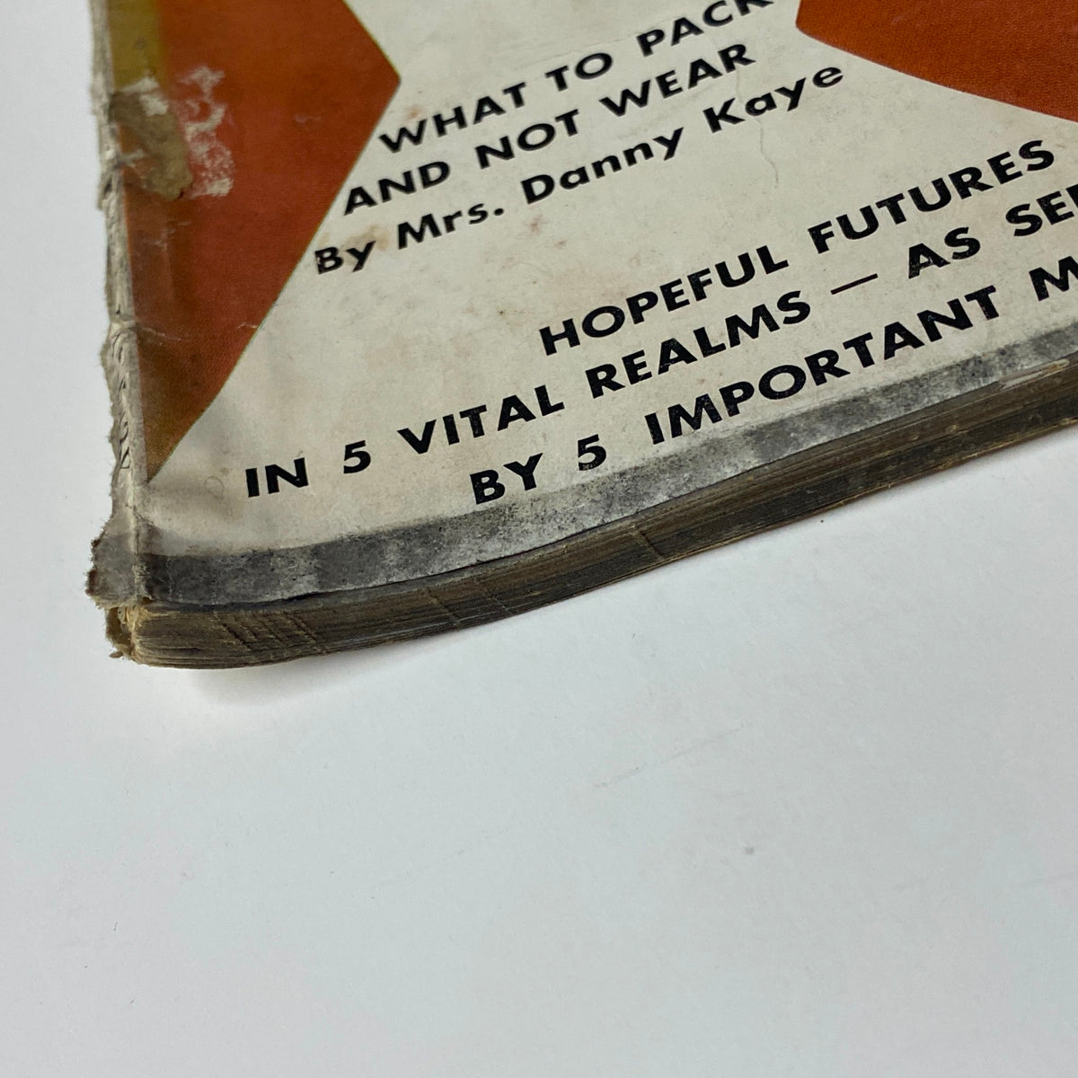 Close-up view of the worn spine of Vogue Magazine January 1, 1962, highlighting the magazine's age and condition, with signs of wear typical for vintage publications.