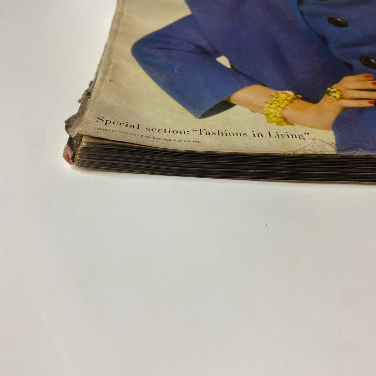 Bottom edge detail of Vogue Magazine September 1, 1957, showing wear with a mention of the 'Fashions in Living' section, demonstrating the magazine's classic vintage condition.