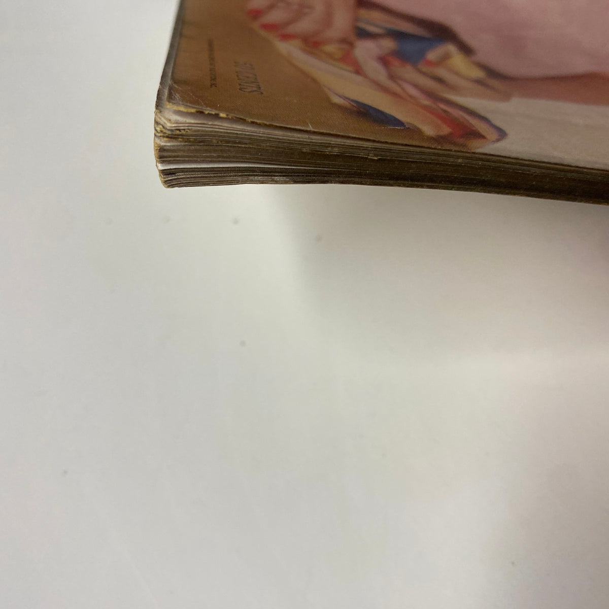 Close-up view of the edge of Vogue Magazine April 15, 1955 Charlotte Payne Cover by Horst P. Horst, showing slight wear and aging on the pages, indicative of its vintage condition.