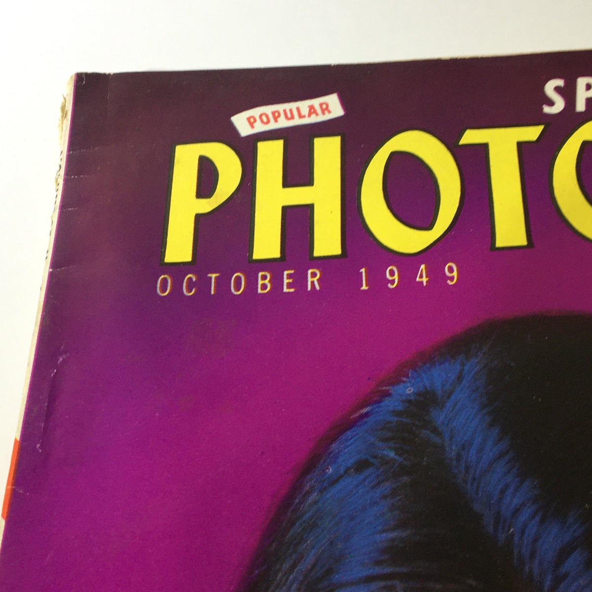 Close-up view of the title section of VTG Popular Photography Magazine October 1949, highlighting the bold typography against a colorful background.