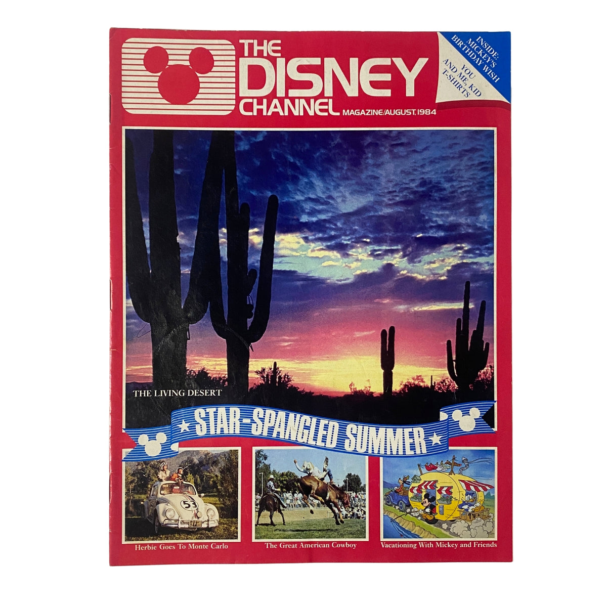 Cover of The Disney Channel Magazine from August 1984 featuring 'The Living Desert', images from 'Herbie Goes to Monte Carlo', 'The Great American Cowboy', and 'Vacationing with Mickey and Friends'. Highlights a vibrant sunset and a star-spangled summer theme.