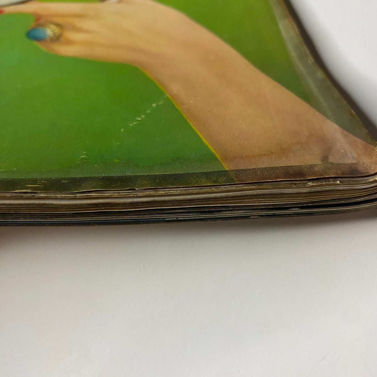 Close-up view of the spine of Vogue Magazine dated April 15, 1957, titled 'How To Keep Your Audience' by Richard Rutledge, showcasing vintage wear with a green background.