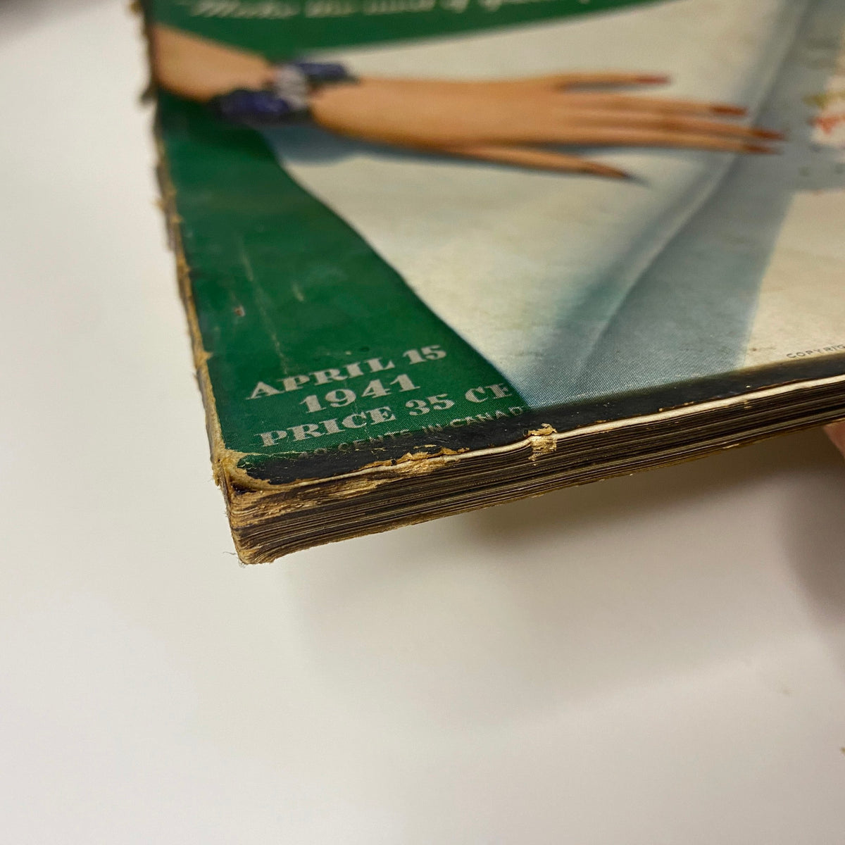 Close-up of the cover edge of Vogue Magazine April 15, 1941, showing signs of wear and the publication date.