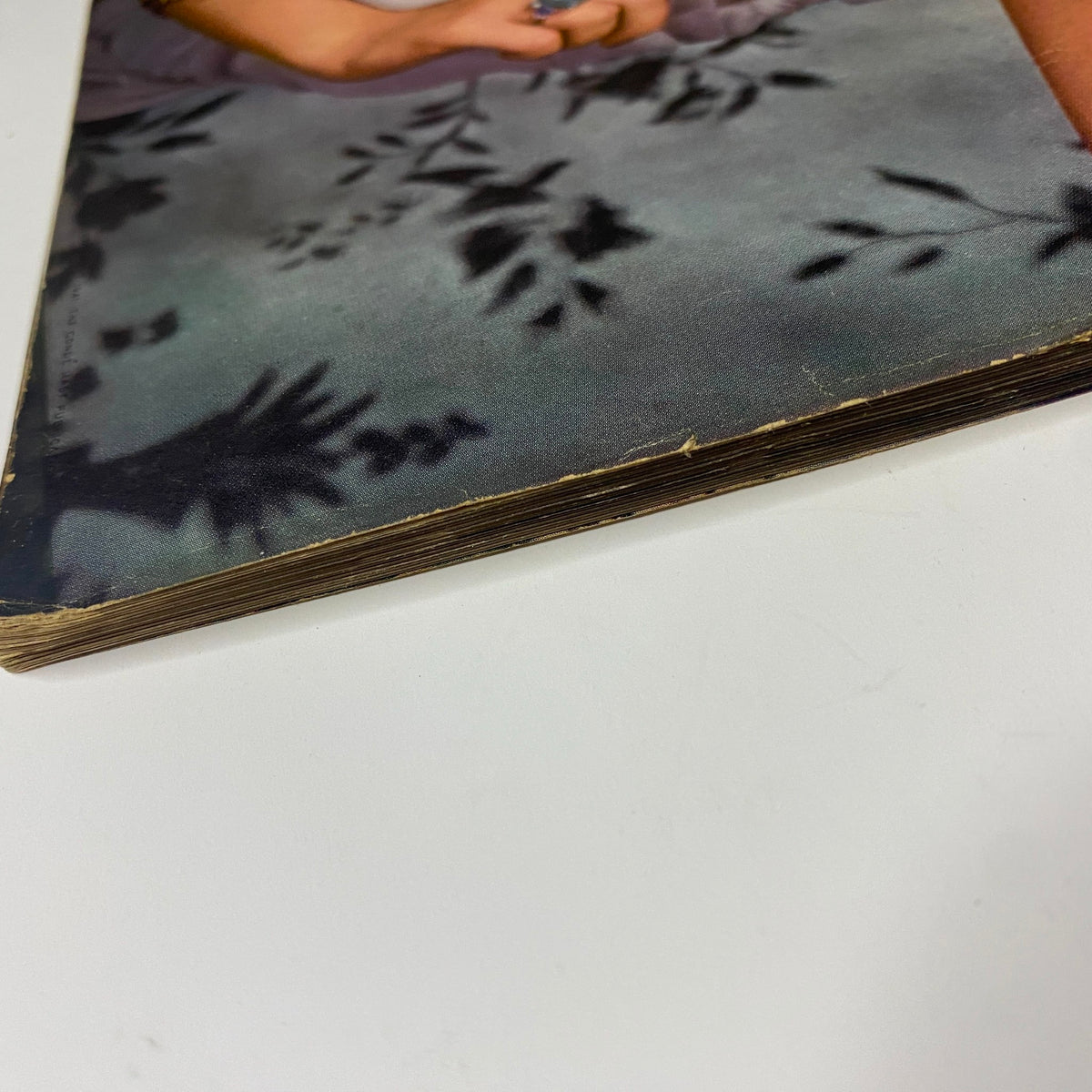 Side view of the aged edges of Vogue Magazine November 1, 1941, depicting signs of wear and tear that signify its historical value as a fashion publication from the early 1940s.