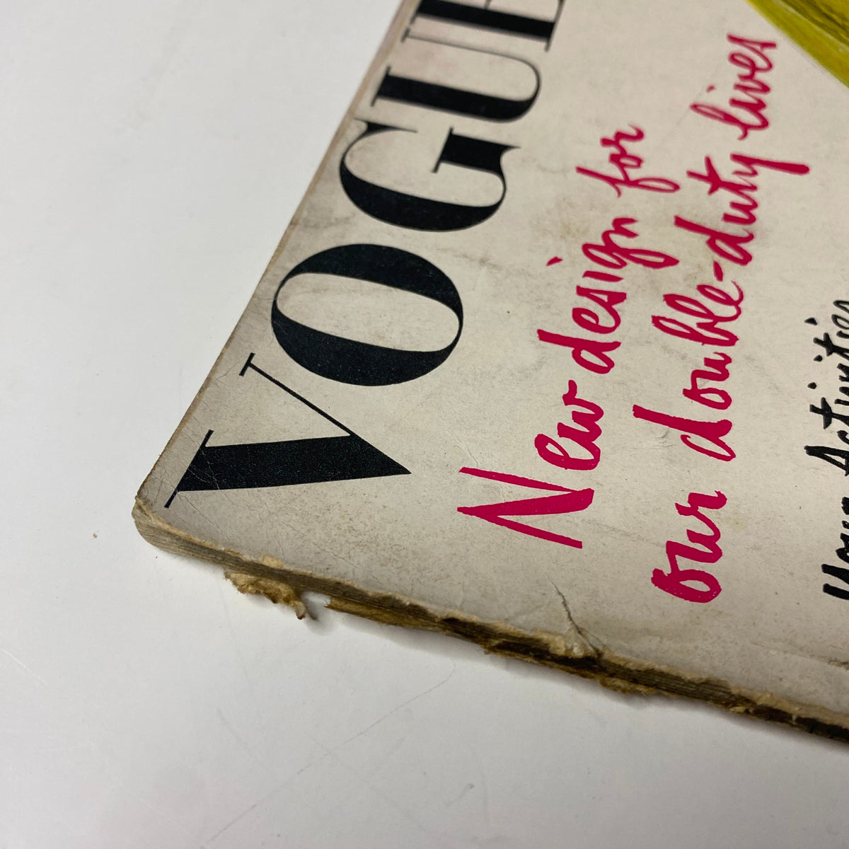 Close-up of the edge of Vogue Magazine January 15, 1942, illustrating the wear and the title 'New Design for Our Double-Duty Lives'.