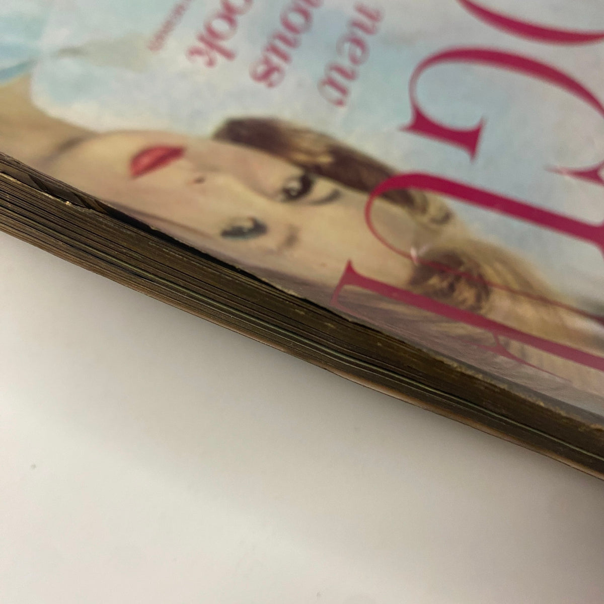 Detailed view of the underside of Vogue Magazine August 1, 1961, showcasing age-related wear, including a slightly frayed edge.