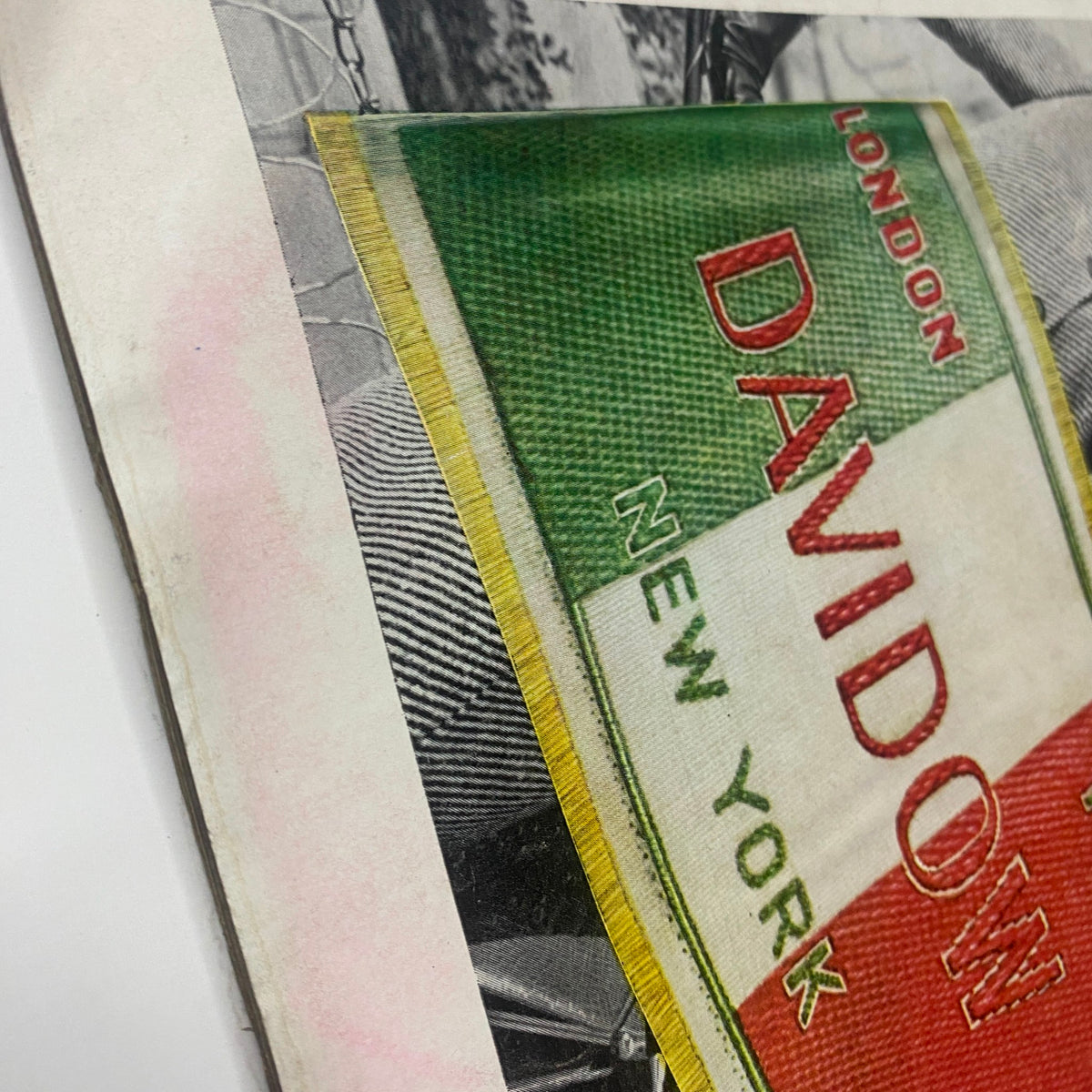 Close-up detail of a page from Vogue Magazine August 1, 1961, showing the label 'DAVIDOW' in red and green colors, highlighting fashion branding of the time.