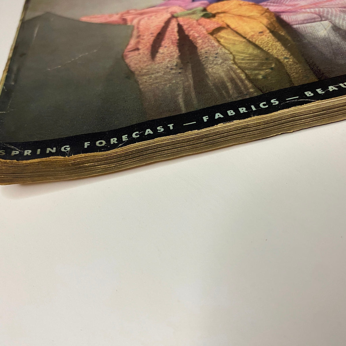 Edge of the Vogue Magazine February 15, 1938 indicating wear, with a focus on the vintage paper quality and the magazine's unique fabric forecast feature.