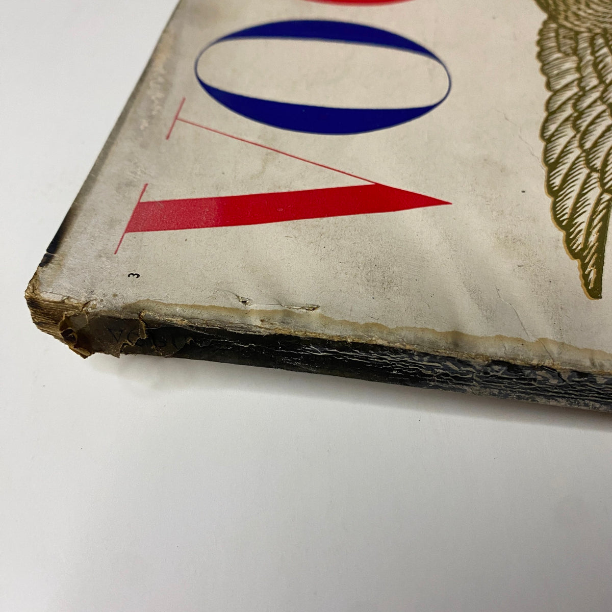 Close-up view of the spine and edge of Vogue Magazine February 1, 1947 Americana Fashion 1947, showing wear and vintage characteristics.
