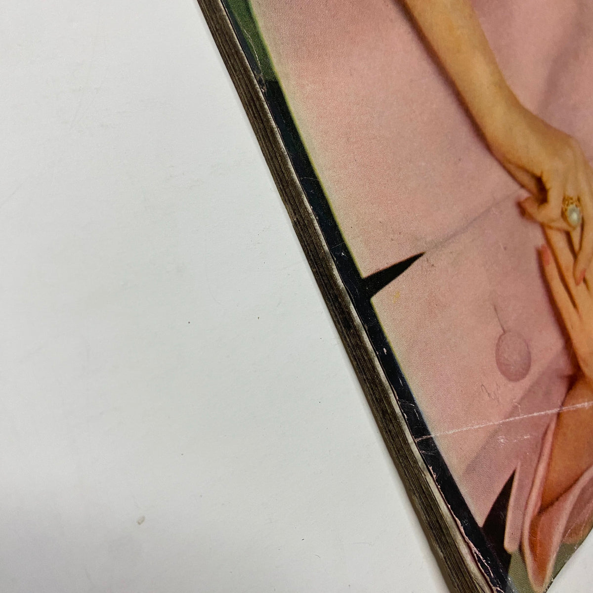 Close-up view of the spine of Vogue Magazine June 1961 Dorothy McGowan Cover by Tom Palumbo, showing edge wear and vintage characteristics.