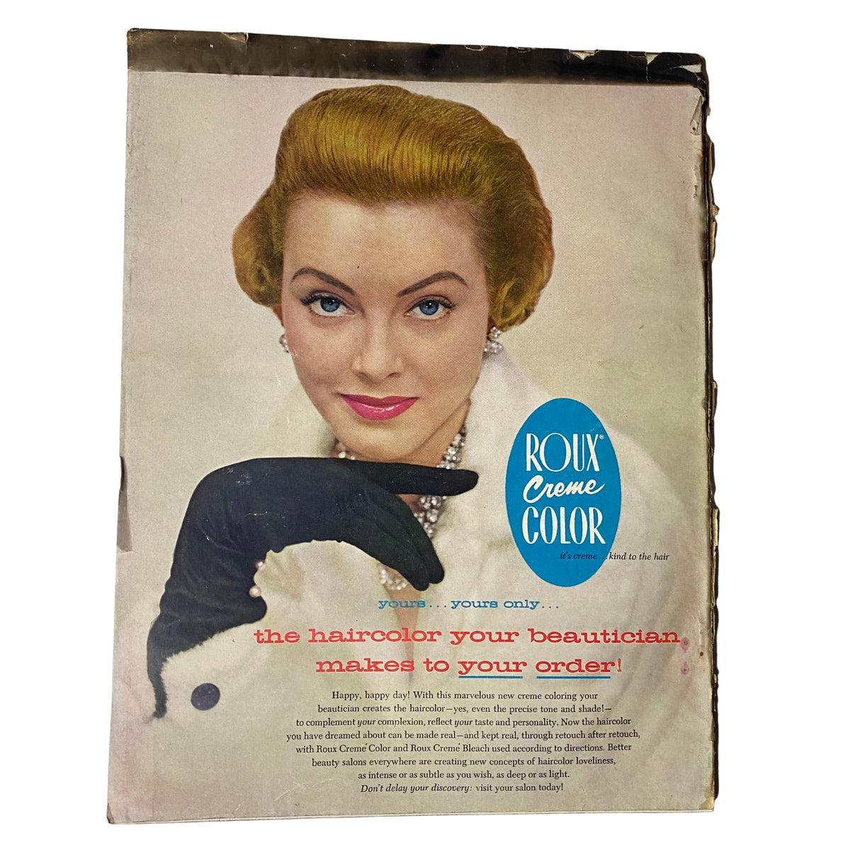 Advertisement for Roux Crème Color hair color, with an elegant model featuring styled blonde hair and wearing a black glove. The ad emphasizes personalized hair color services, reflecting vintage beauty standards. It connects to the fashion and beauty themes showcased in Vogue Magazine May 1, 1955.