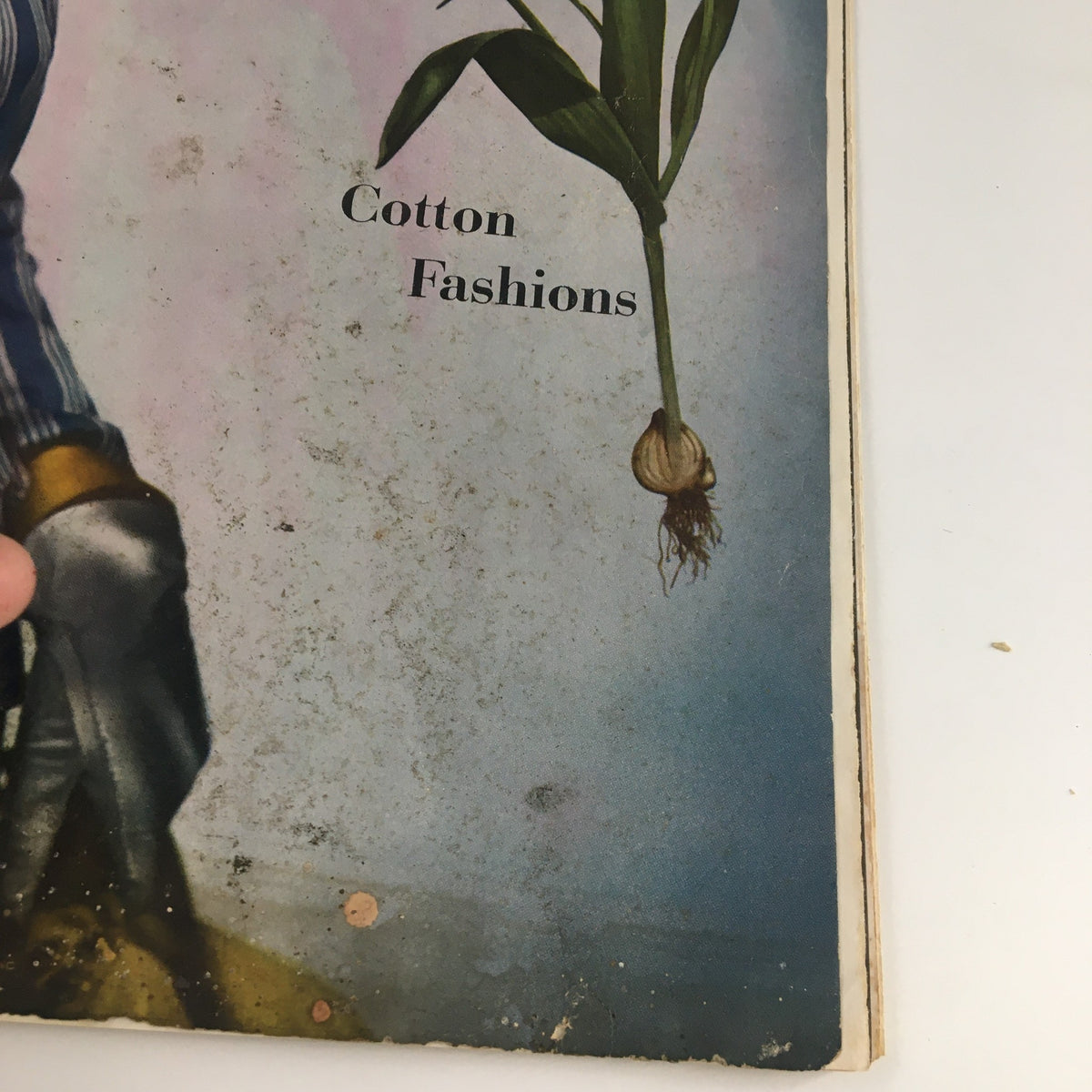 Focus on the cotton fashions text on the Vintage Vogue Magazine May 1 1944 cover, depicting a model with flowers.