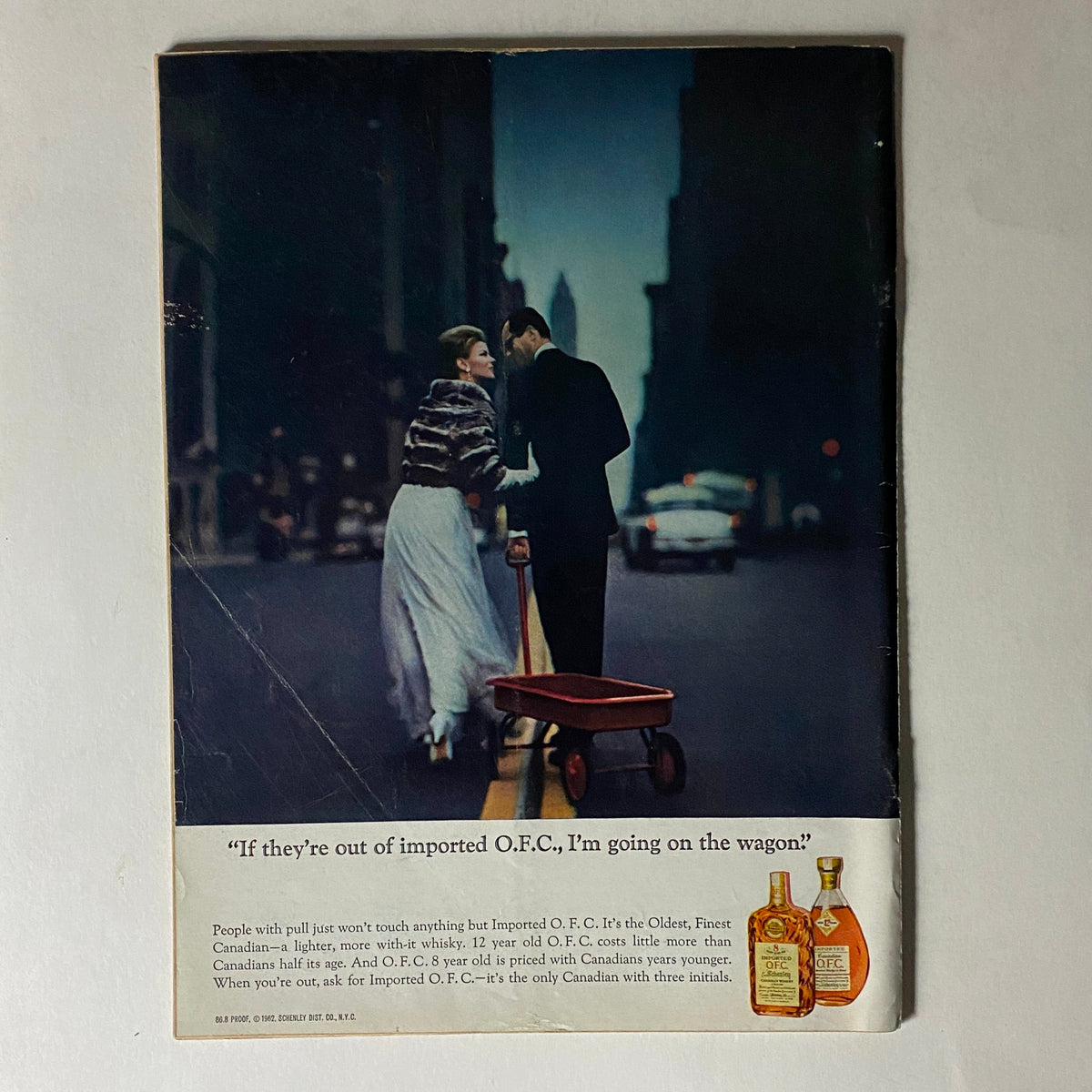 Advertisement on the back cover of The New Yorker, July 6, 1963, featuring a stylish couple in a city street with a cart, promoting Imported O.F.C. whisky.