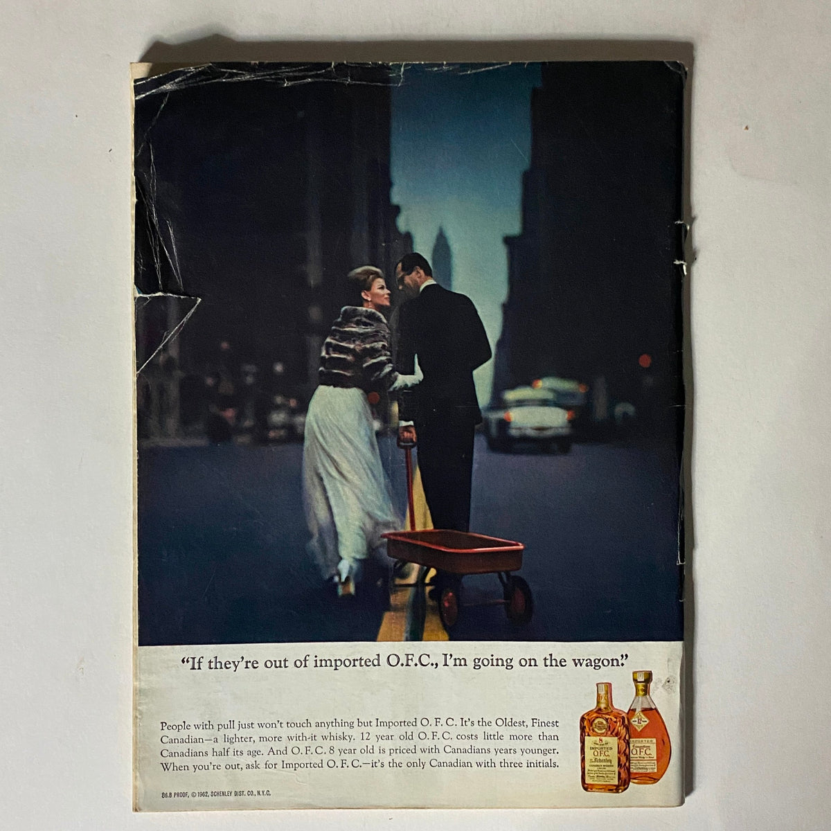 Back cover of The New Yorker magazine January 19, 1963, featuring an advertisement for imported O.F.C. whisky, depicting a couple in formal attire on a city street.