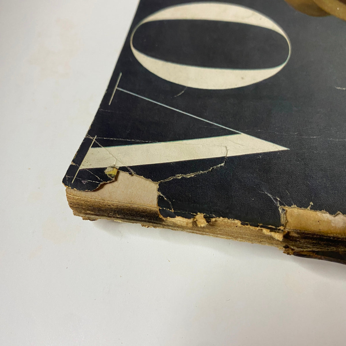 Close-up view of the worn spine of Vogue Magazine February 15, 1945, illustrating the vintage wear and tear that adds character to this historical publication.