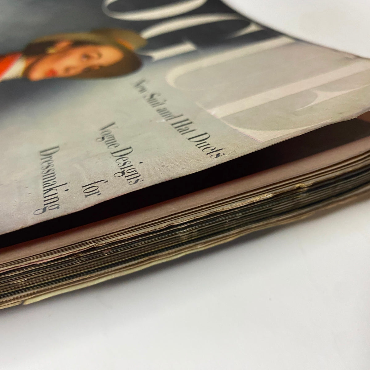 View of the spine of Vogue Magazine February 15, 1945, highlighting worn edges and vintage characteristics of a historical magazine.