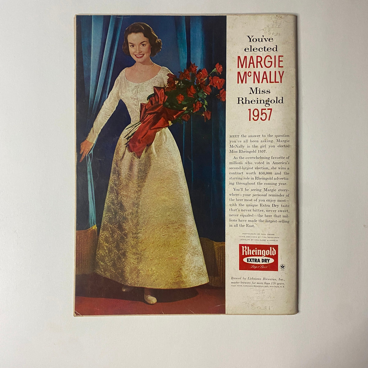 Back cover of Gourmet Magazine January 1957 featuring a colorful advertisement for Rheingold Beer, showcasing a woman in a formal dress holding a bouquet of flowers.