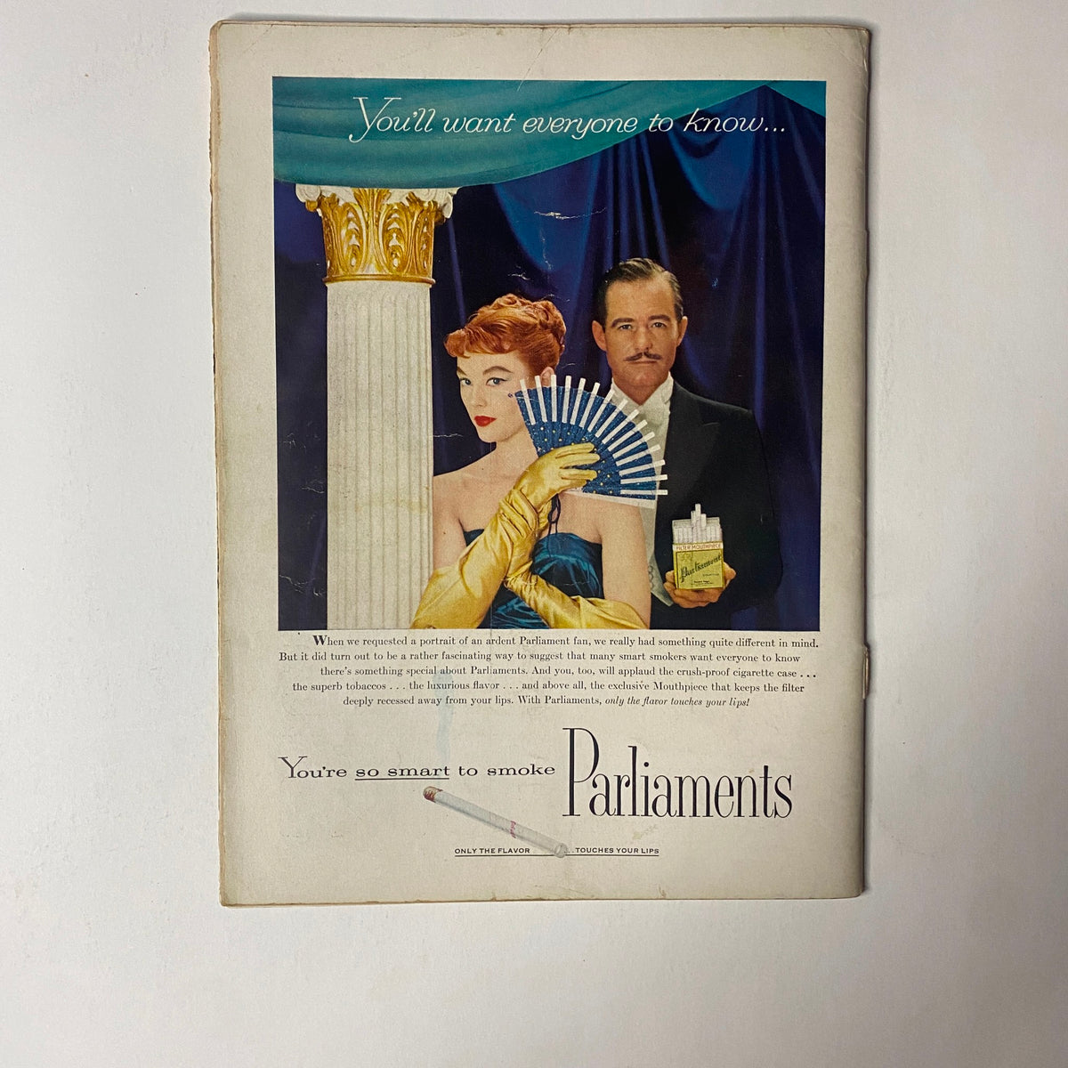 Advertisement from the back of Gourmet Magazine February 1956 featuring a glamorous woman and a man promoting Parliament cigarettes, styled to reflect mid-century aesthetics.