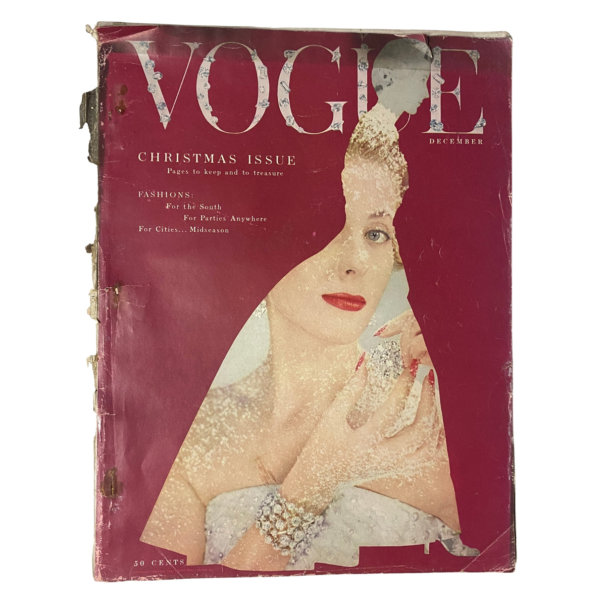 Cover of Vogue Magazine December 1953 featuring Kathleen Wallace by Erwin Blumenfeld. The cover showcases a Christmas-themed design, with a striking image of a woman adorned in pearls and snowflakes, revealing vintage wear and tear.