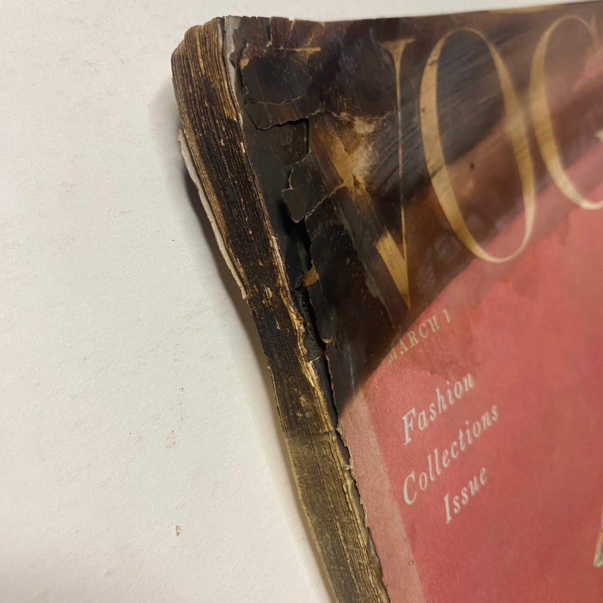 Detail view of the spine and edge of Vogue Magazine March 1, 1954, illustrating the vintage wear, including creases and worn edges. Features Mary Jane Russell and Cherry Nelms highlighting Parisian fashion.