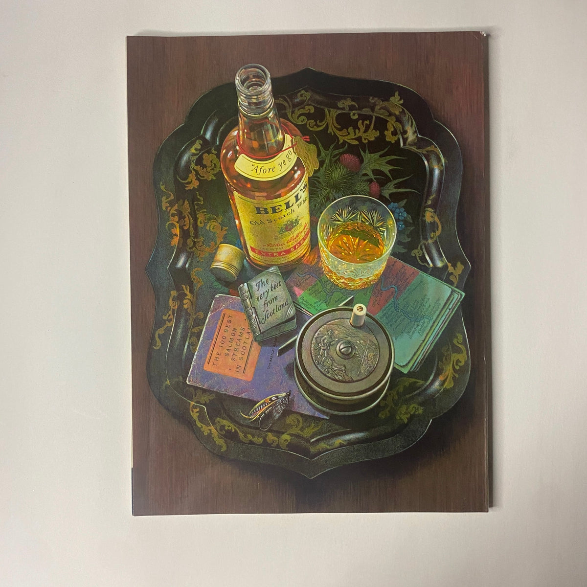 Artwork of a vintage still life with a bottle of whiskey, a glass, and assorted notebooks, showcasing intricate detailing, presented on a decorative tray.