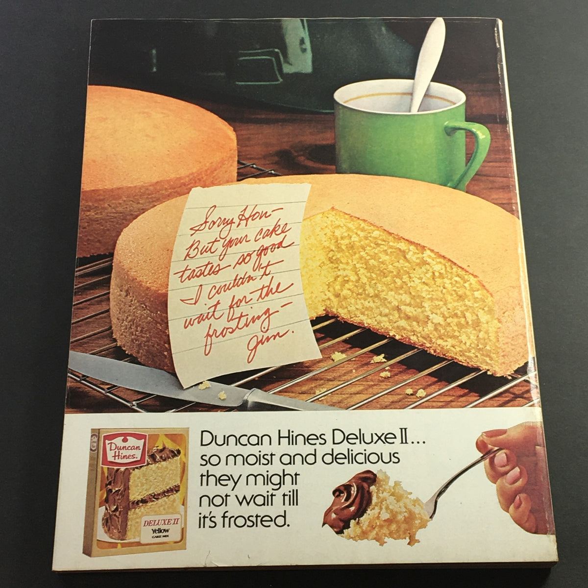 Back cover of VTG Good Housekeeping Magazine April 1978, displaying a cake advertisement for Duncan Hines with a playful note, featuring a freshly baked cake and a coffee cup.