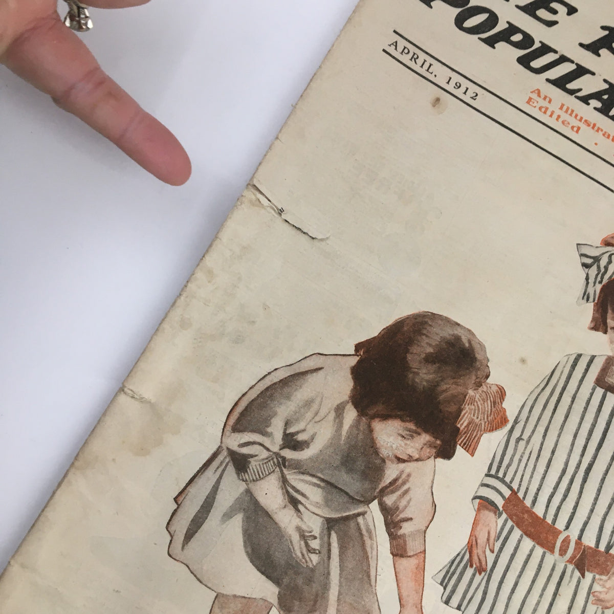 Close-up of the cover of VTG The People's Popular Monthly April 1912, showcasing wear and character with children and bunnies.